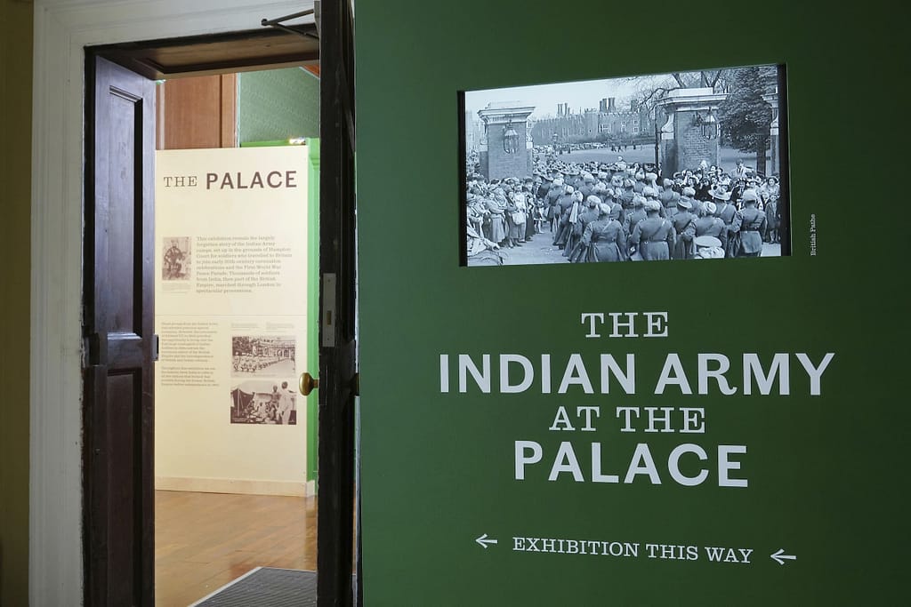 Indian Army at the Palace exhibition 2023. The entrance to the exhibition, showing a video of archive newsreel footage of the Indian Army arriving at Hampton Court Palace. The 2023 Indian Army at the Palace exhibition explores the forgotten story of Indian Army soldiers who camped at Hampton Court Palace in the early 20th century, through a display of previously unseen objects, photographs, film and personal stories.